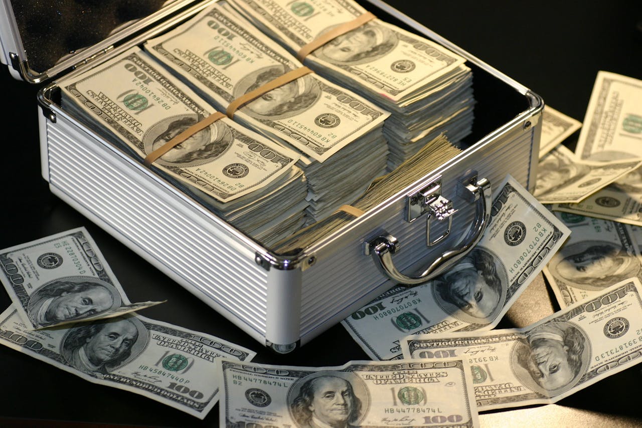 service-03 A metallic briefcase full of US dollar bills, symbolizing wealth and investment.